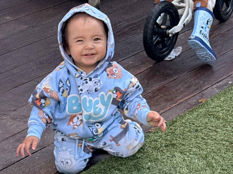 Happy baby outdoors smiling at camera